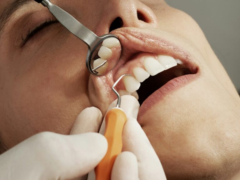 Lekarz dentysta bada zęby pacjenta, chirurgia stomatologiczna w Pile